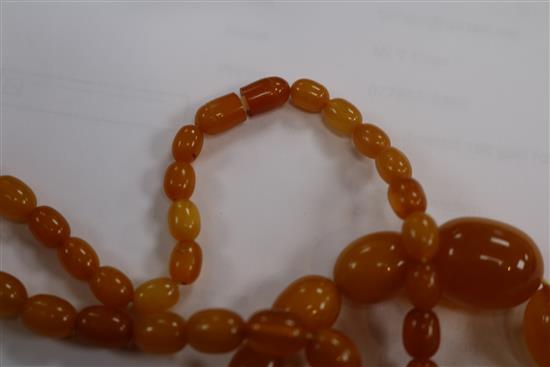A single strand amber bead necklace, 28grms and an amber cigar holder.